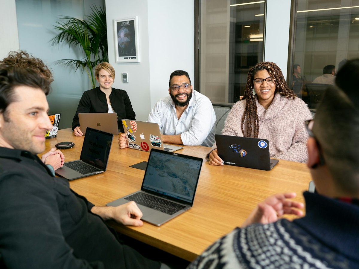 Team members meeting around a table in the office
